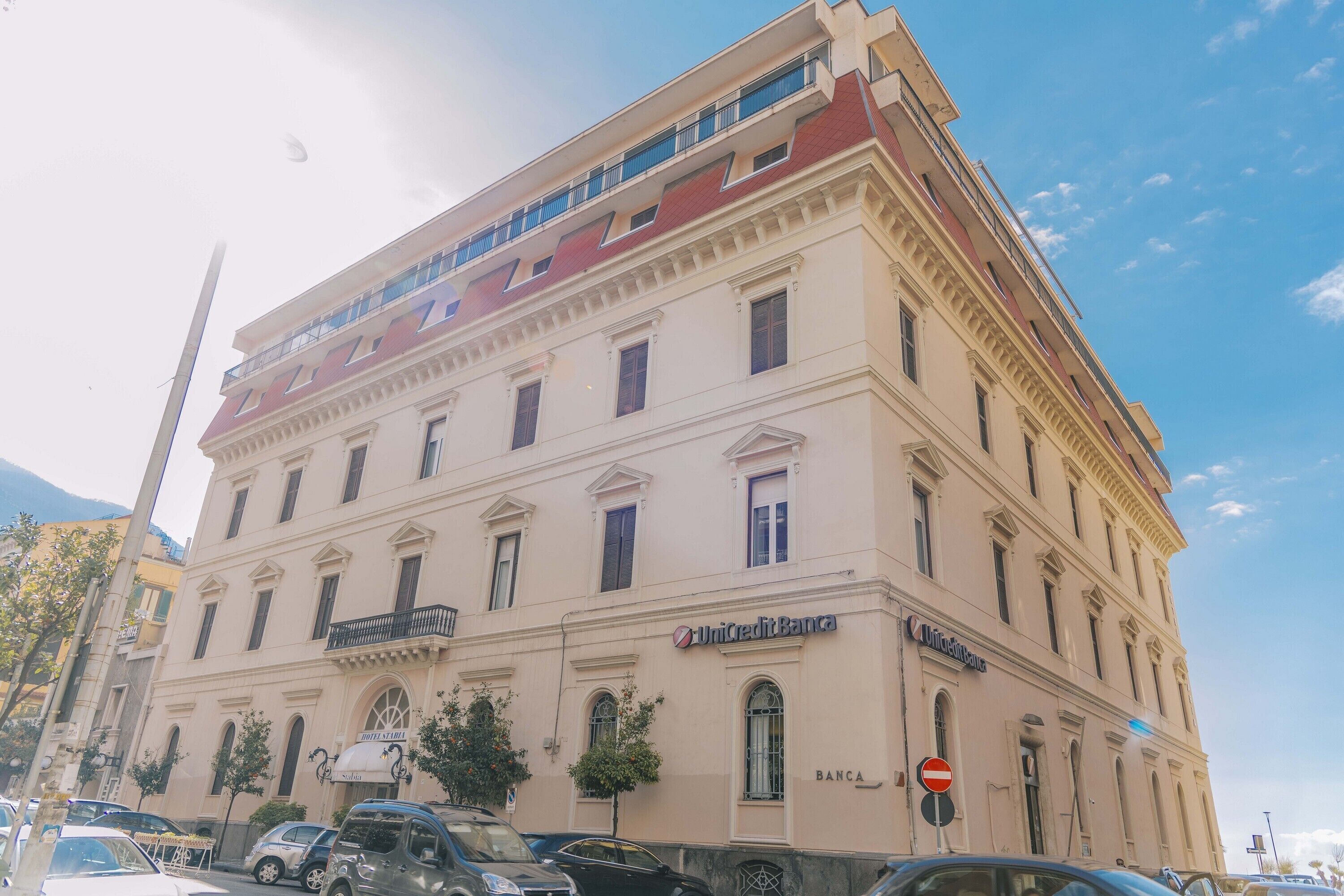 Un immeuble à plusieurs étages portant les enseignes « UnicreditBank », « Sofitel » et « BANCA ».