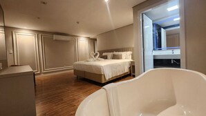 A modern bedroom with a large bed, a bathtub, and a walk-in closet. - Del Rey Quality Hotel (Foz do Iguaçu)