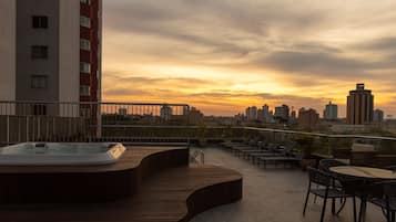 Una piscina al aire libre, sombrillas, sillones reclinables de piscina