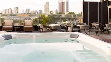 Una piscina al aire libre, sombrillas, sillones reclinables de piscina