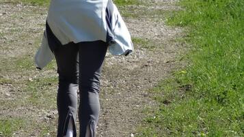 A person walking on a dirt path surrounded by greenery.