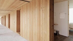 A corridor with wooden panel walls and a door leading to a bathroom. - Hörger Biohotel und Tafernwirtschaft (Kranzberg)