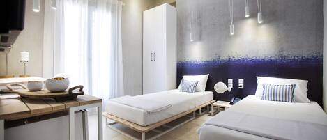A modern hotel room with two beds, a kitchenette, a large window with curtains, and a wall-mounted light fixture.