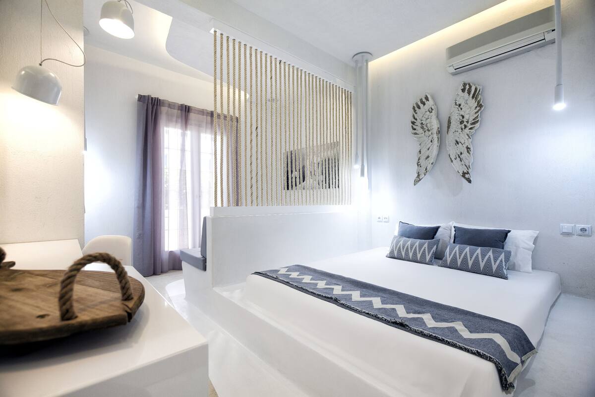 Une chambre à coucher moderne avec un lit, une table de chevet et des œuvres d’art décoratives au mur.
