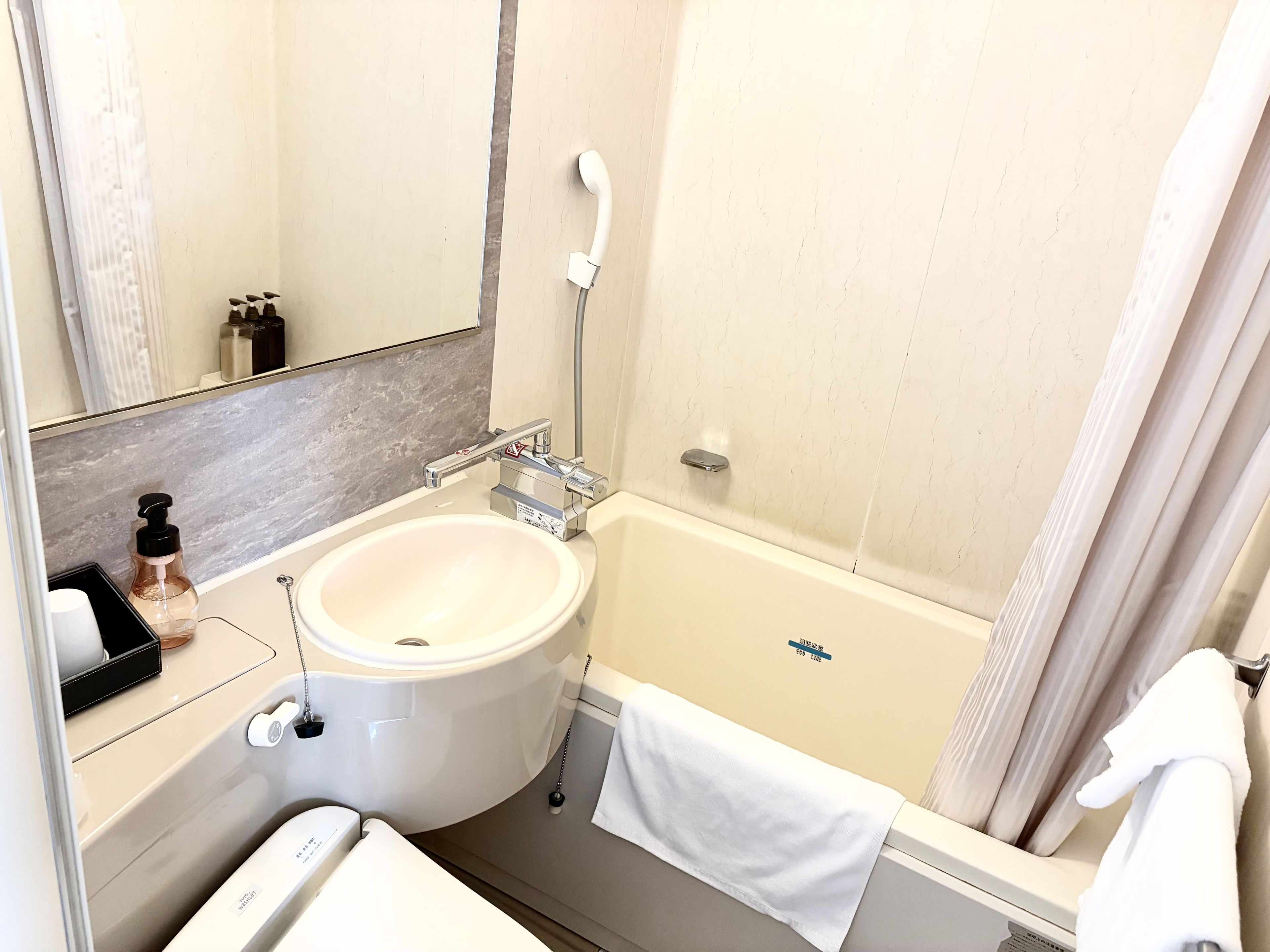 A bathroom with a white sink, a bathtub, and a shower.