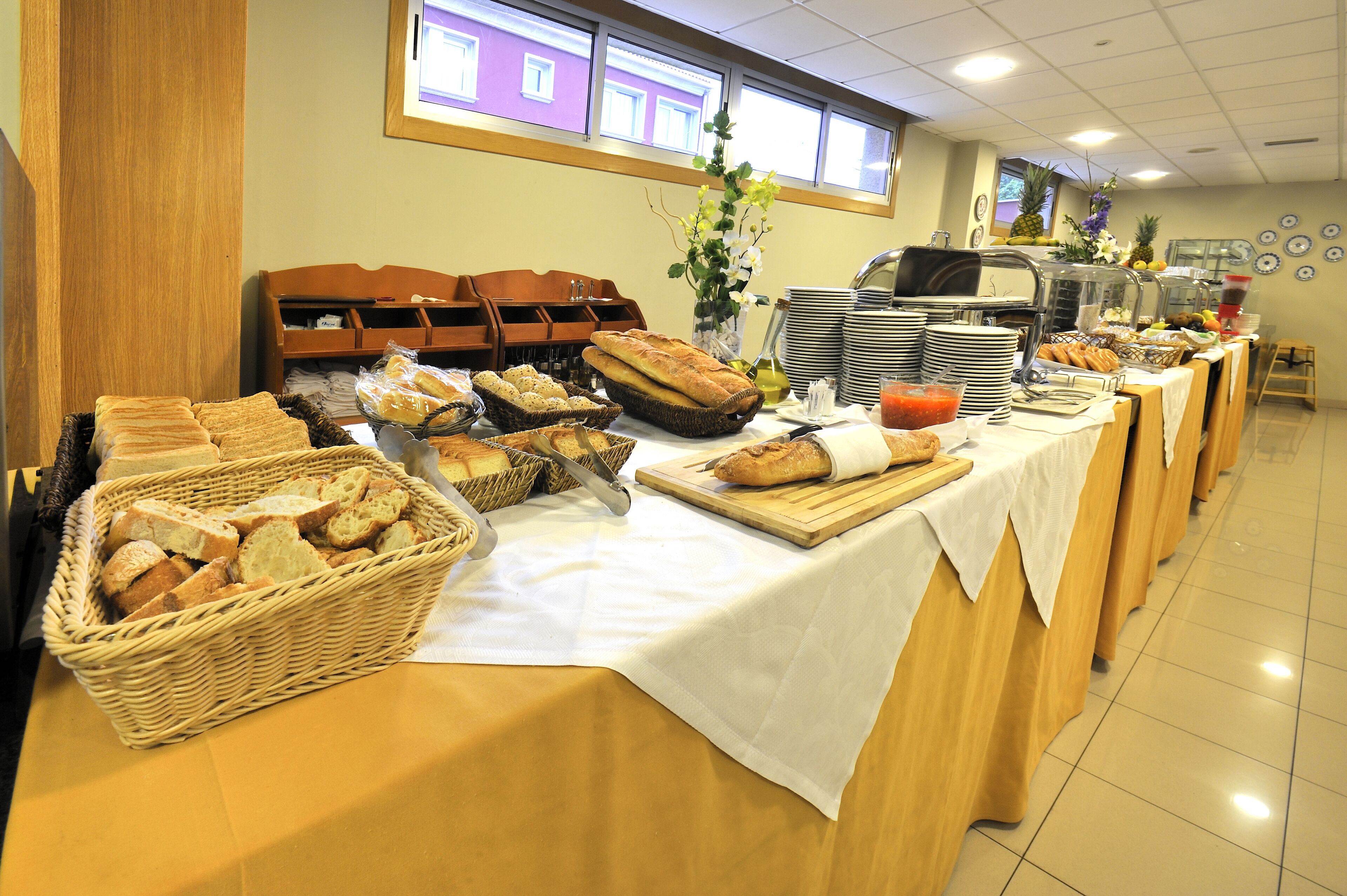 A buffet setup with various breads, baskets, and a fruit display.