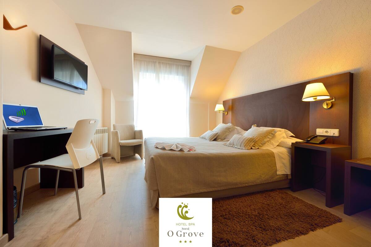 Une chambre d’hôtel équipée d’un lit, d’un bureau, d’une chaise et d’un téléviseur.