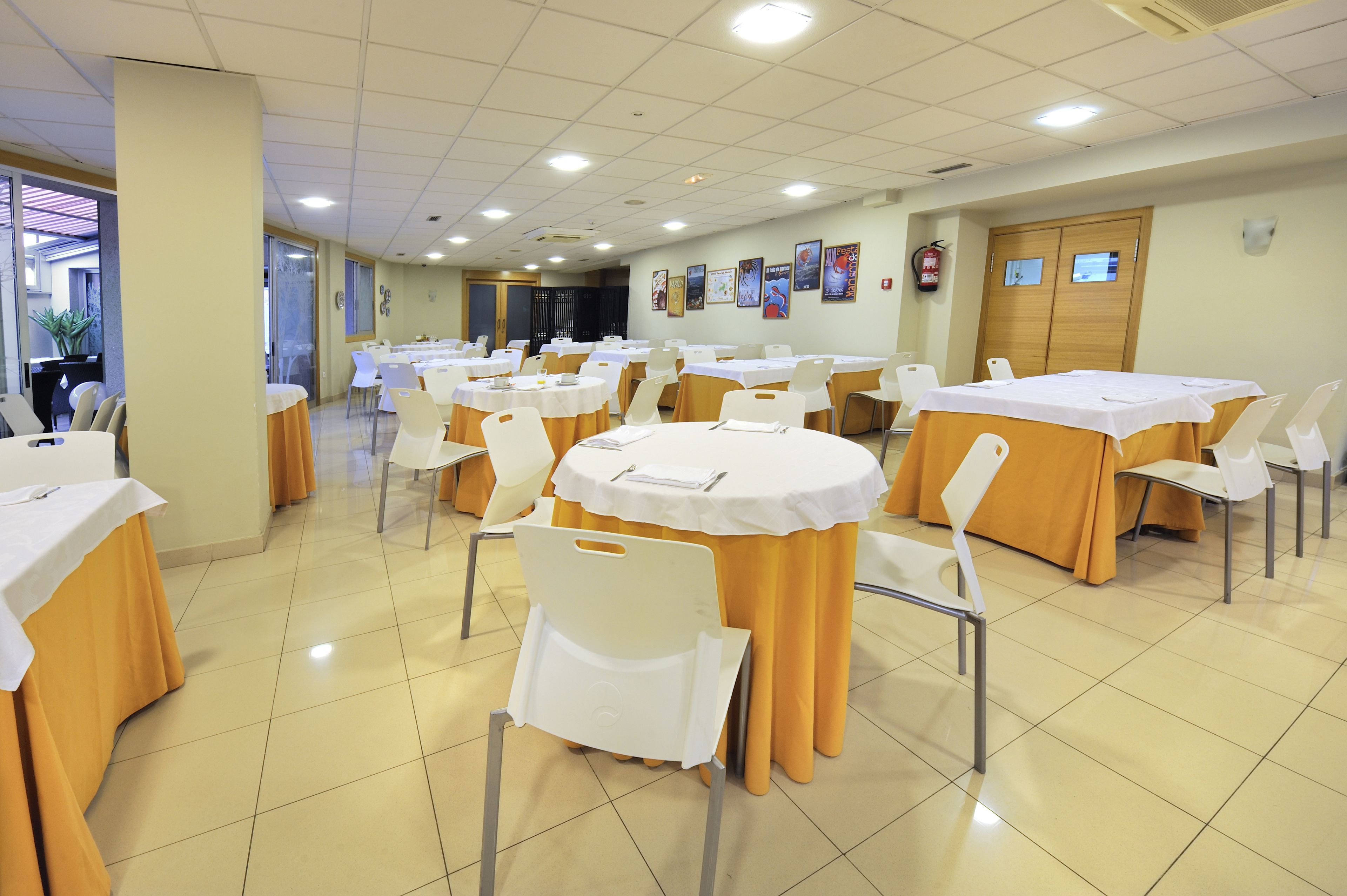 A conference room with multiple tables and chairs, arranged in rows.