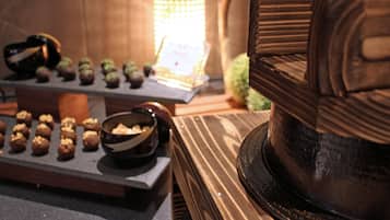 A table with a variety of food items, including a chocolate cake and several small pastries.