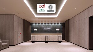 Un moderno vestíbulo de hotel con un cartel de certificación GSTC, una recepción y una zona de estar.