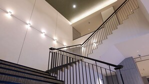Una escalera moderna con barandales negros e iluminación empotrada.