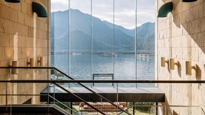 A modern interior with a large window offering a view of a lake and mountains. - Aki Grand Hotel & Spa (Hatsukaichi)