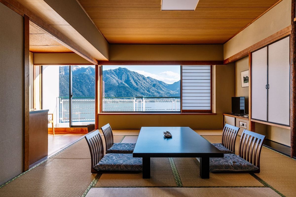 A traditional Japanese room with tatami flooring, a low table, and cushions.