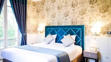 Una habitación de hotel con una cama grande, dos mesitas de noche y una ventana con cortinas.