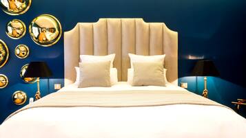 Una habitación de hotel con una cama grande, dos lámparas de noche y varios espejos en la pared.