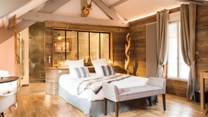 Un dormitorio moderno con una cama grande, paredes de madera, un banco empotrado y vistas al exterior.