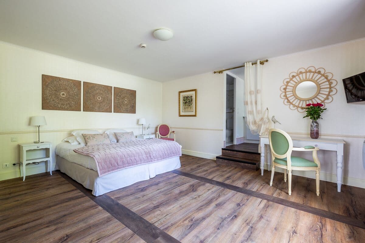 A bedroom with a bed, nightstands, a desk, and a chair.