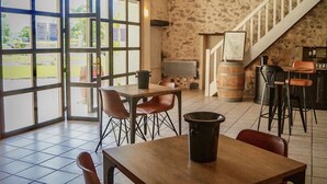 Interior de restaurante con pared de piedra, una escalera y un cartel que dice 'CHÂTEAU MEYRE'.