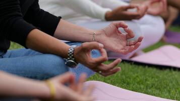 People sitting on yoga mats outdoors.