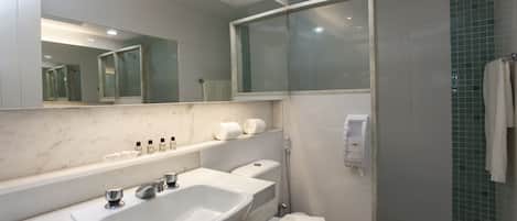 A modern bathroom with a large mirror, a sink, a toilet, and a shower area.
