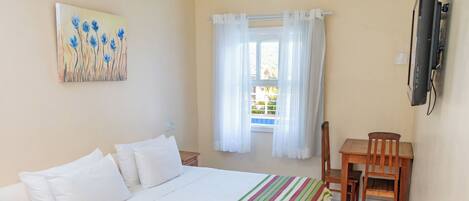 Un dormitorio con una cama, un escritorio y una silla.