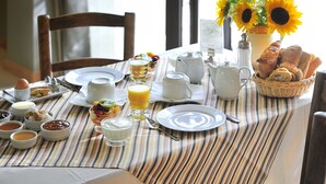 A breakfast table with various dishes, including eggs, toast, and a fruit bowl. - Hotel Charembeau (Forcalquier)