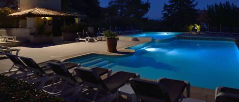 Een seizoensgebonden buitenzwembad en parasols bij het zwembad