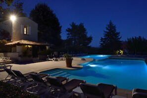 A swimming pool with lounge chairs and a building with a tiled roof. - Hotel Charembeau (Forcalquier)