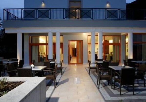 A two-story building with a covered outdoor seating area and a central entrance. - U Pramenu (Plzen)