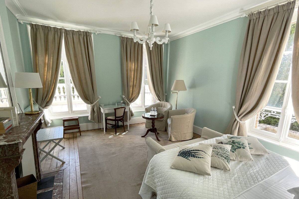 Un dormitorio con una cama grande, un escritorio, una silla y una mesita.
