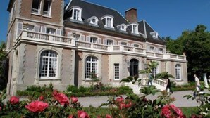 Un grand bâtiment historique doté de nombreuses fenêtres et d’une façade symétrique.