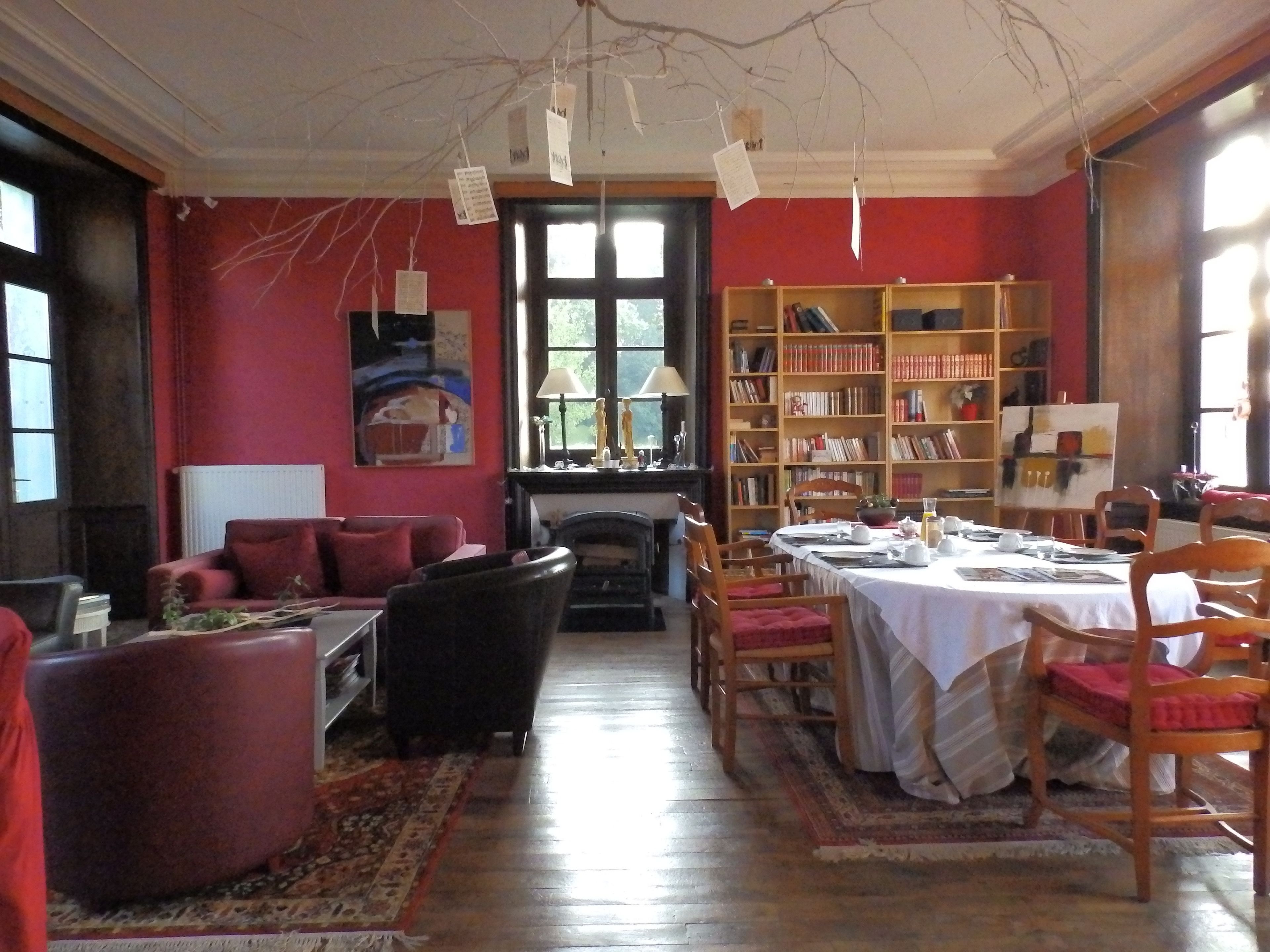 A cozy living room with a fireplace, a dining area, and a bookshelf filled with books.