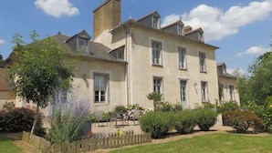 A large, two-story building with multiple windows and a garden in front. - Château du Pin (Iffendic)