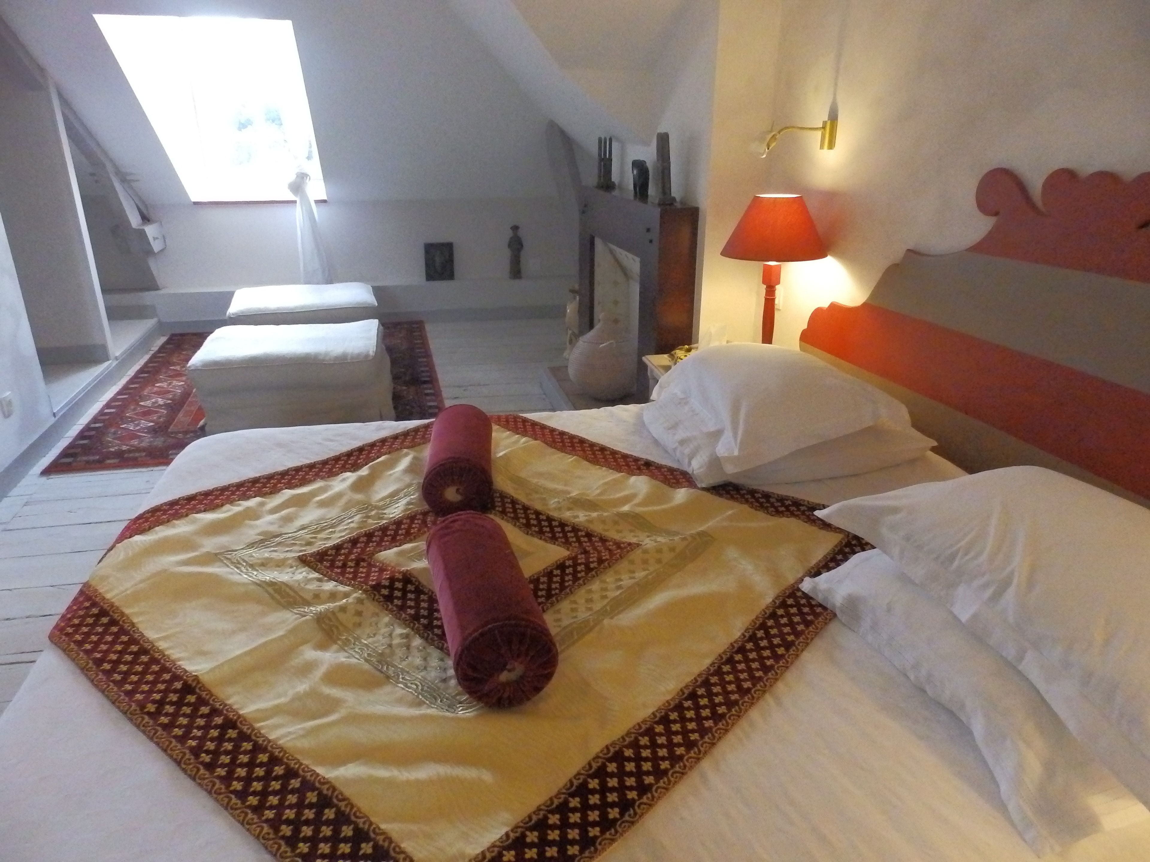 Habitación de hotel con una cama grande, una ventana, una lámpara y vistas al cielo.