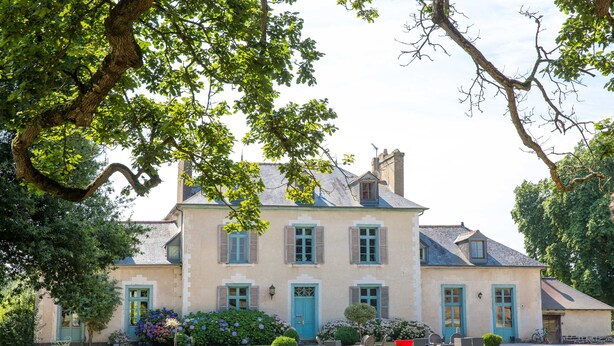 A large, two-story house with a symmetrical facade, multiple windows, and a well-maintained lawn. - Château du Pin (Iffendic)