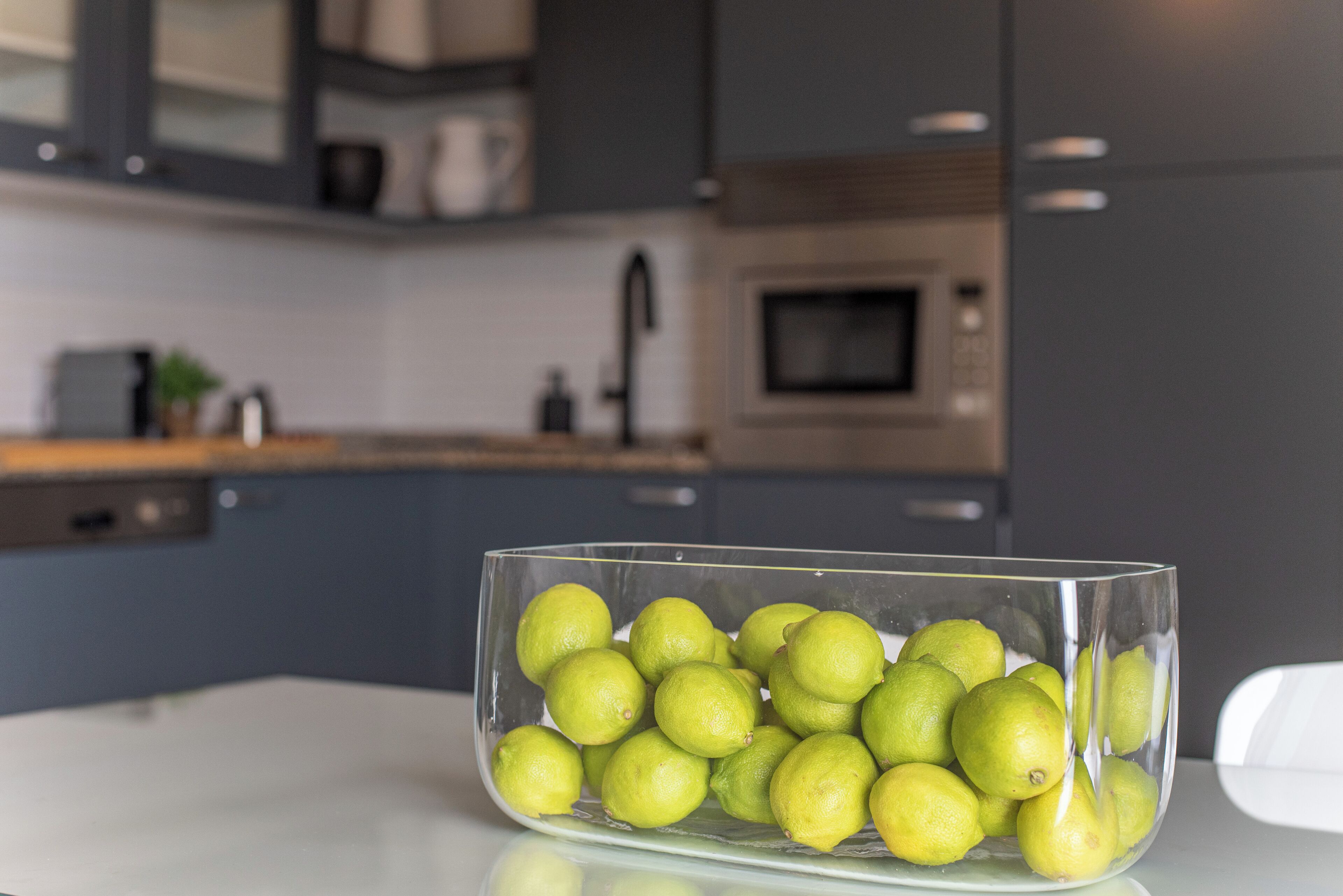Una cocina con un bol de limones sobre una encimera blanca.