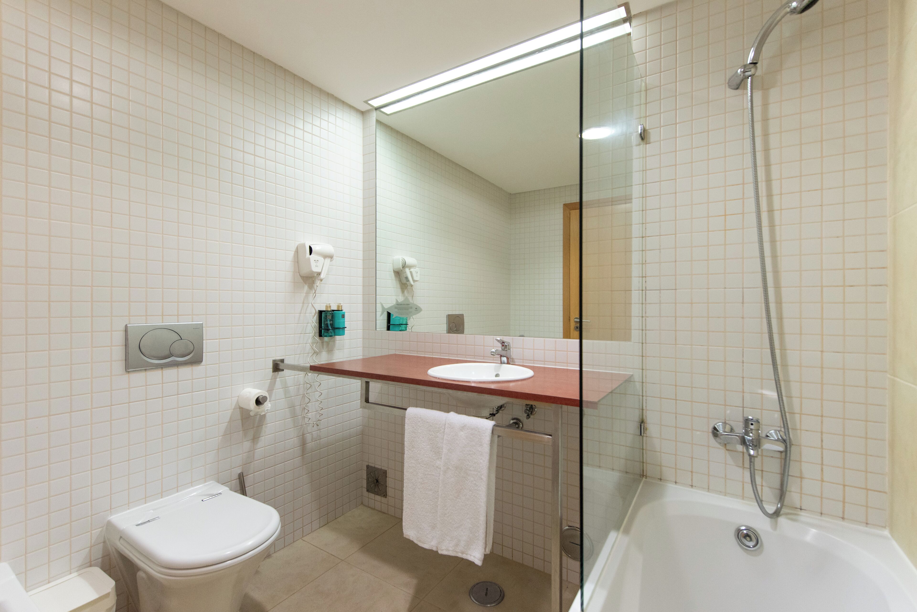 A bathroom with a toilet, sink, and shower.