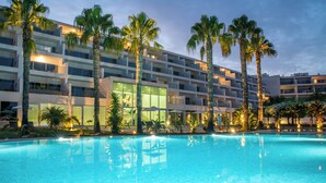Una piscina con un edificio de hotel moderno al fondo.