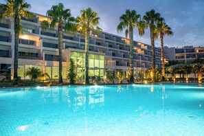 Una piscina al aire libre de temporada, sombrillas