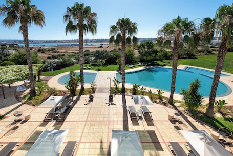 Una piscina al aire libre de temporada, sombrillas