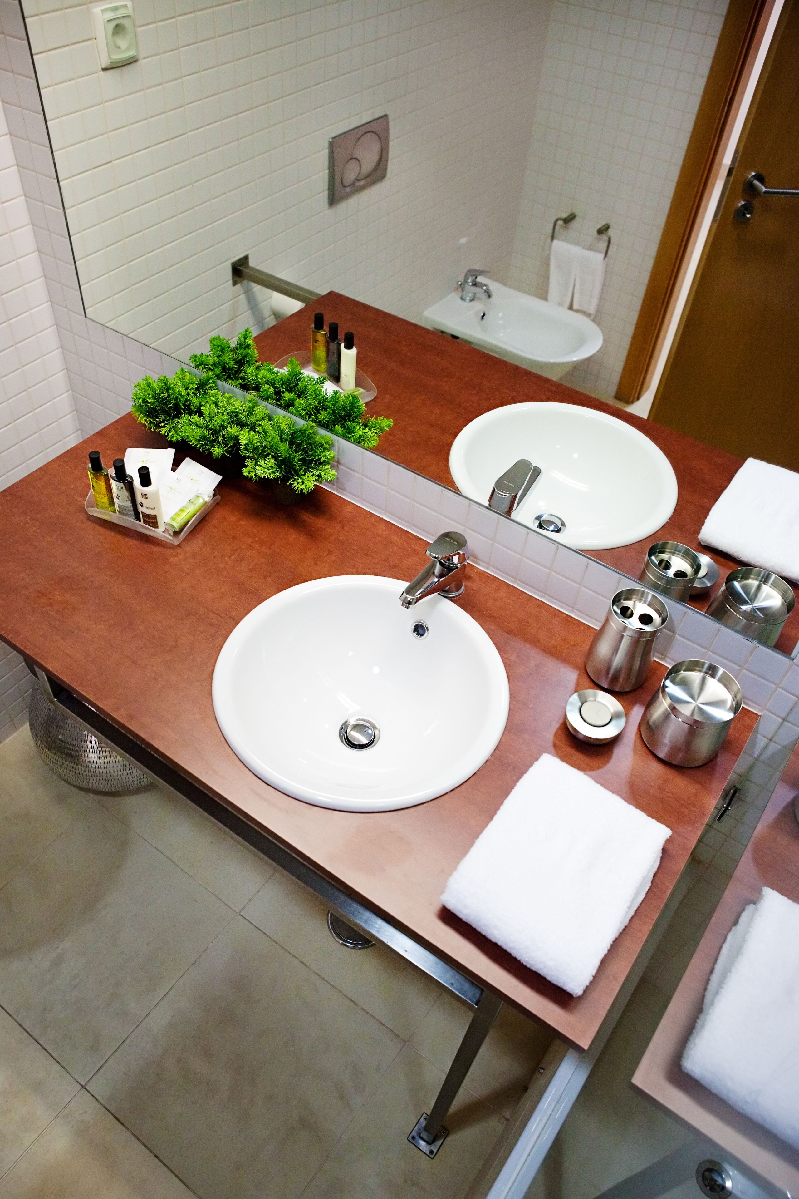 A bathroom with two sinks, a mirror, and toiletries.
