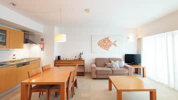 Una sala de estar moderna con una mesa de comedor, sofá y televisor.