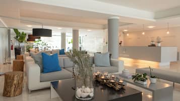 A modern living room with a sofa, coffee table, and decorative elements like a vase and candles.