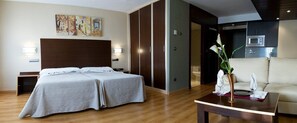 A hotel room with a double bed, a sofa, a dining table, and a kitchen area. - Snö Ciudad de Sabiñanigo (Sabinanigo)