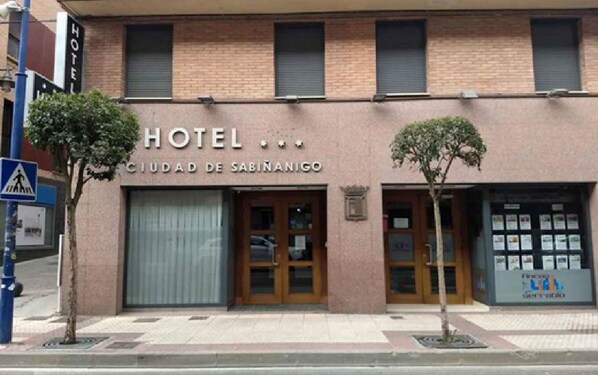 La façade d’un hôtel, sur laquelle on peut lire l’inscription « HÔTEL CIUDAD DE SABINANIGO ».