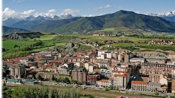 Poble amb una combinació d'edificis residencials i comercials, envoltat de muntanyes.