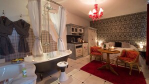A bathroom with a bathtub, a sink, and a toilet. There is a vanity with a mirror and a towel rack. - Le Mascaret (Blainville-sur-Mer)