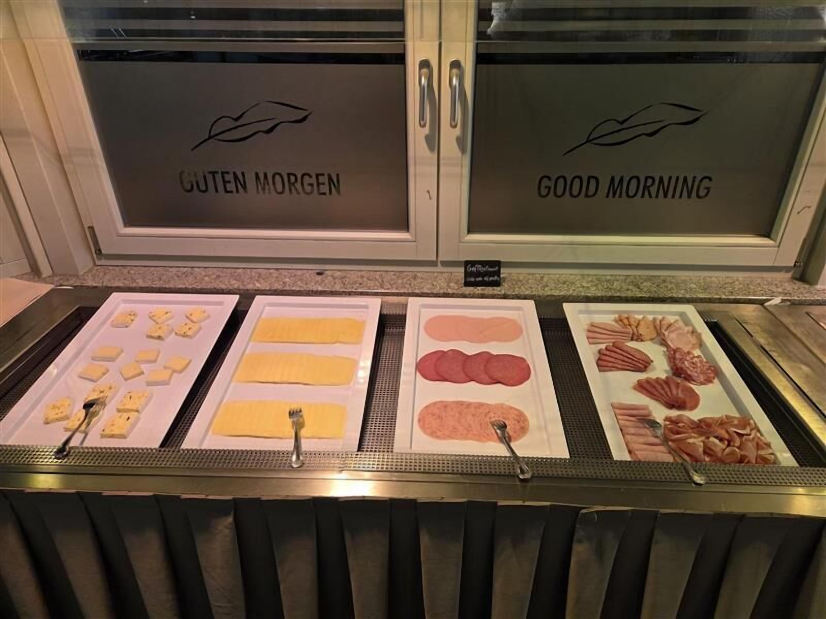 A breakfast buffet with labeled sections for 'Guten Morgen' and 'Good Morning'.