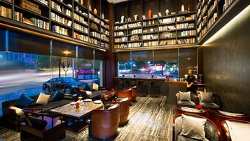 Una biblioteca moderna con estanterías, asientos y vista a la calle.