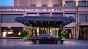 L’extérieur de l’hôtel Kasion Purey se caractérise par une façade moderne, de grandes fenêtres en verre et un espace d’entrée abrité.